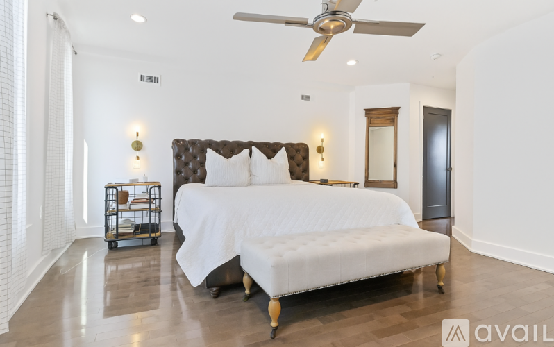 A bedroom with a large bed and a ceiling fan.