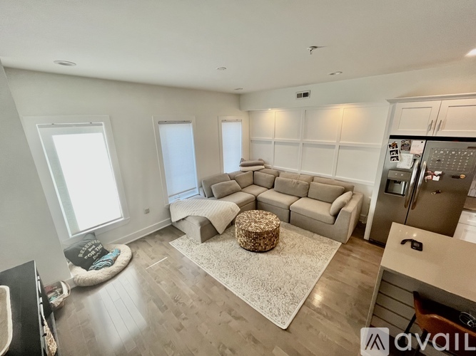 A spacious living room with a grey sofa set and a coffee table in the center.