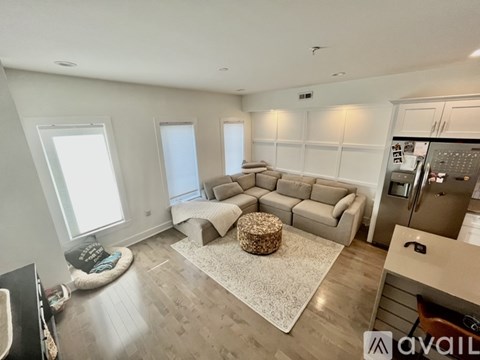 A spacious living room with a grey sofa set and a coffee table in the center.