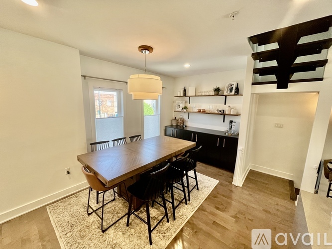 A dining room with a wooden table and chairs.