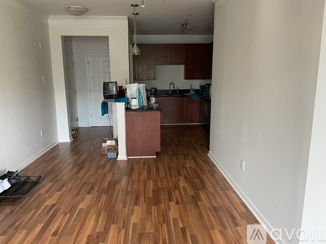 A kitchen with wooden floors and white walls.