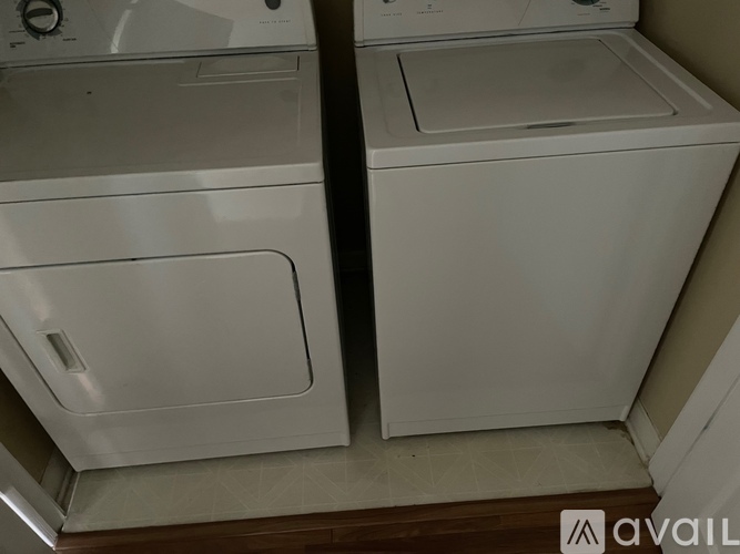 Two white washing machines in a small room.