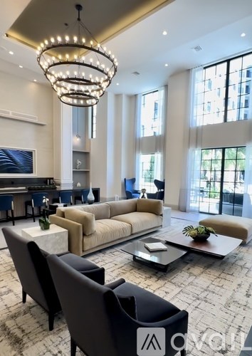 A modern living room with a large chandelier and a sectional sofa.