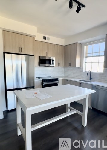 A modern kitchen with a white table and stainless steel appliances.