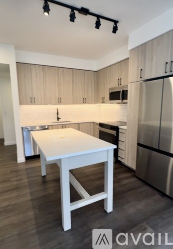 A kitchen with a white table and stainless steel appliances.