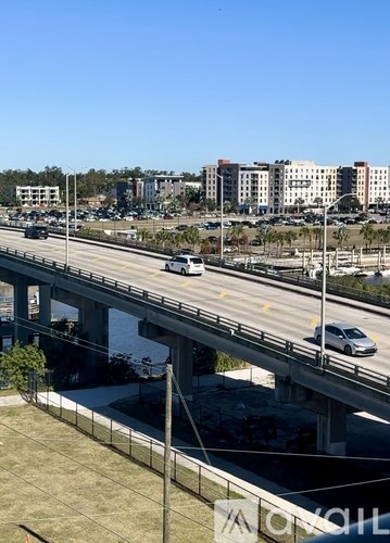 A highway with cars driving on it and buildings in the background.