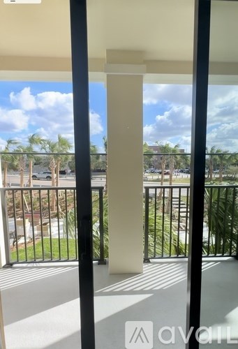 A balcony with a view of a parking lot and trees.