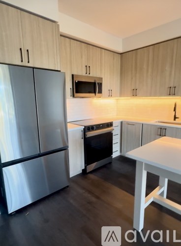A kitchen with a stainless steel refrigerator and a white table.