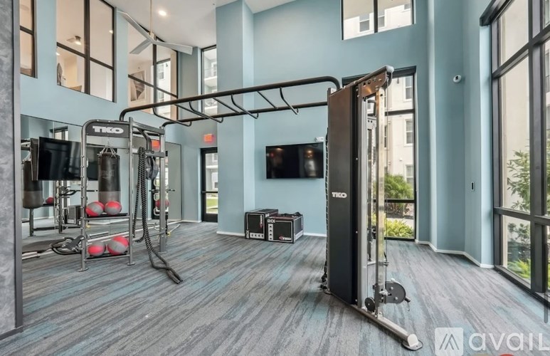 A gym with a variety of equipment including a treadmill, weights, and a television.
