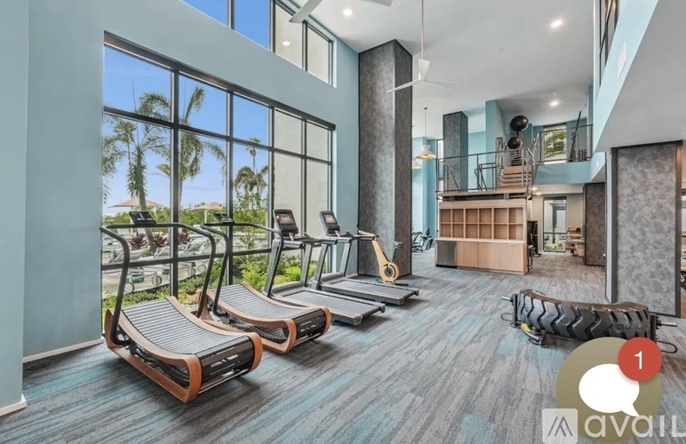 A gym with treadmills and a view of the outside.