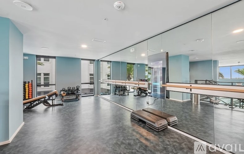 A spacious room with a mirrored wall and a bench.