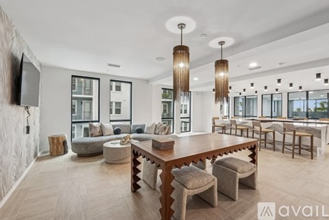 A spacious living room with a long wooden table and multiple chairs.