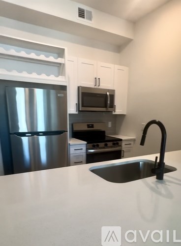 A kitchen with a sink, refrigerator, and microwave.