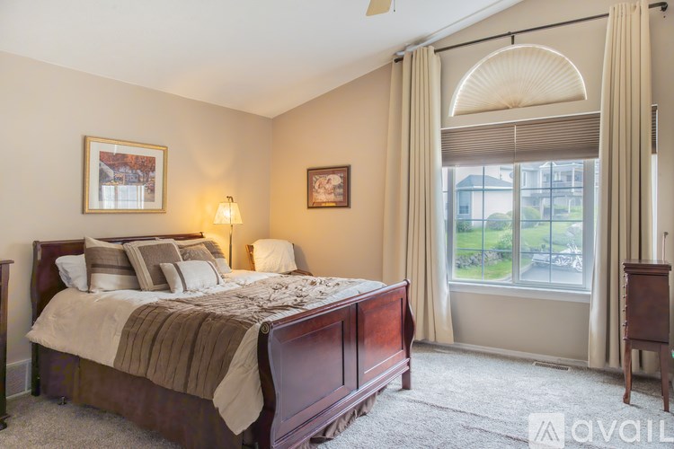 A bedroom with a large bed and a window with a view of the outside.