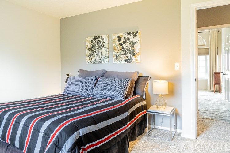 A bedroom with a bed, nightstand, and two wall art pieces.