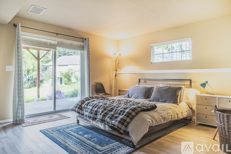 A bedroom with a bed, nightstand, and window.