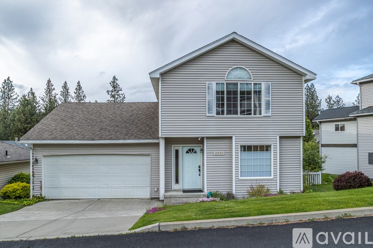 A house with a grey siding and a white door is available for sale.