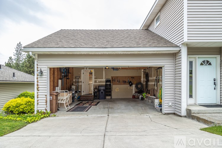 A garage with a white door and a grey roof.