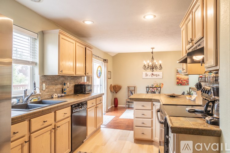 A kitchen with wooden cabinets and a chandelier.