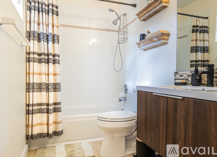 A bathroom with a toilet, a shower, and a wooden cabinet.