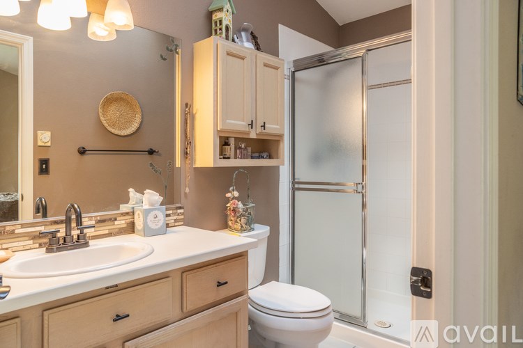 A bathroom with a white toilet, sink, and a mirror.