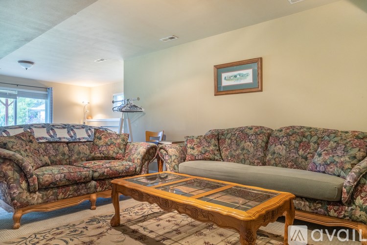 A living room with two floral patterned couches and a coffee table.