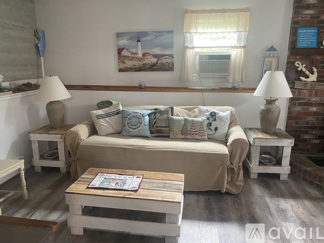 A living room with a couch, two lamps, and a painting on the wall.