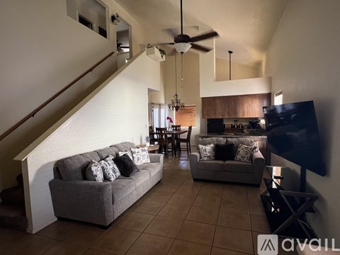 A living room with a grey couch and a television.