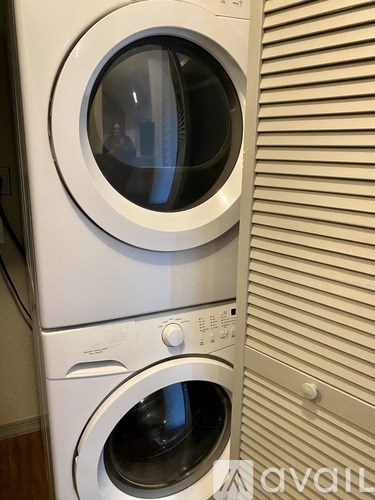 A stack of white front loading washing machines.