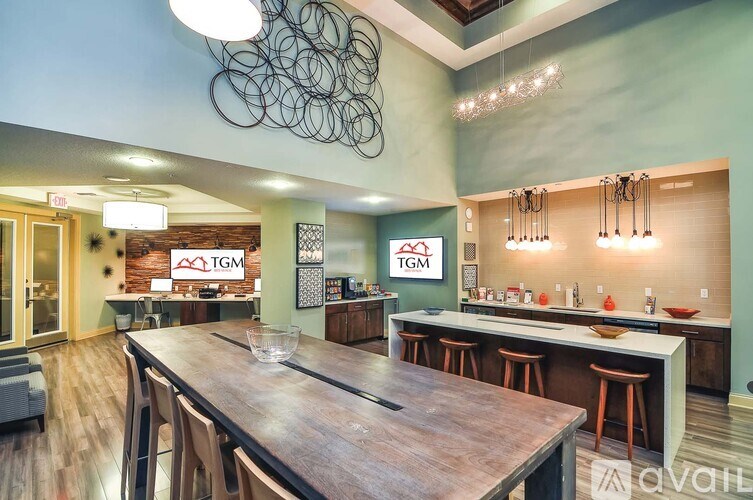 A modern kitchen with a wooden table and bar stools.