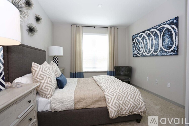 A bedroom with a large bed and a painting on the wall.
