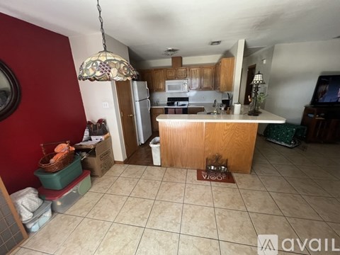 A kitchen with a red wall and a wooden island.