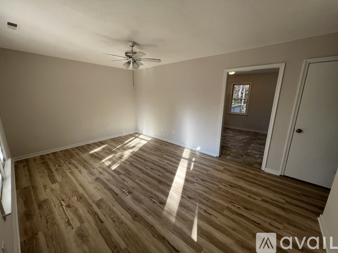 A room with wooden flooring and a ceiling fan.