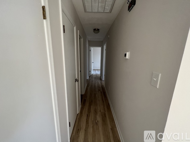 A long hallway with doors on both sides and a light on the wall.