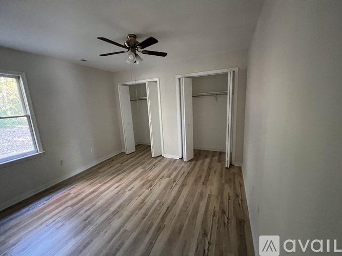 A room with a ceiling fan and wooden flooring.