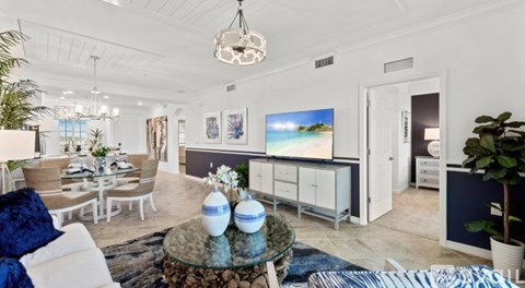 A living room with a white couch and a glass coffee table.