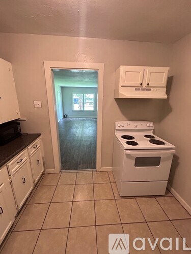 A kitchen with a white oven and black countertops.