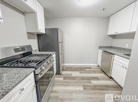 A kitchen with a granite countertop and a stove top oven.