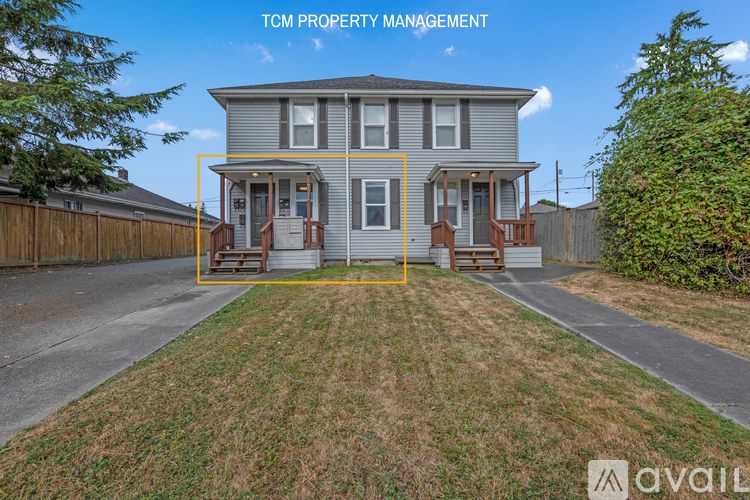A house with a front yard and a sign that says "TCM PROPERTY MANAGEMENT".