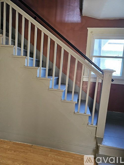 A staircase with white railings and a wooden handrail.