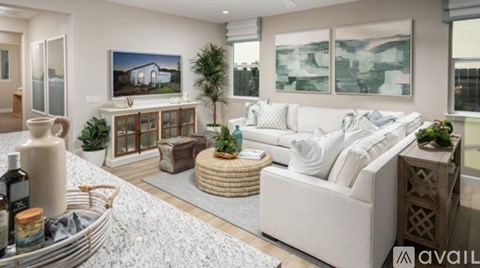 A modern living room with a white sofa and a painting on the wall.