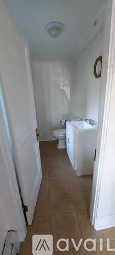 A bathroom with a toilet, sink, and mirror.