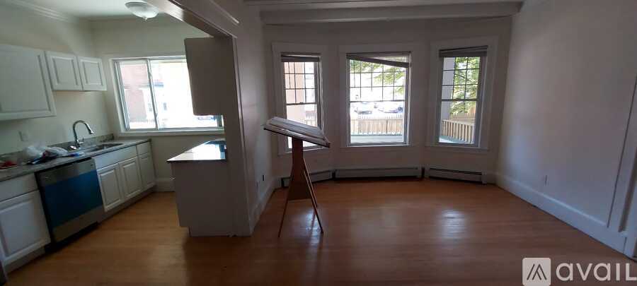 A kitchen with white cabinets and a wooden floor.