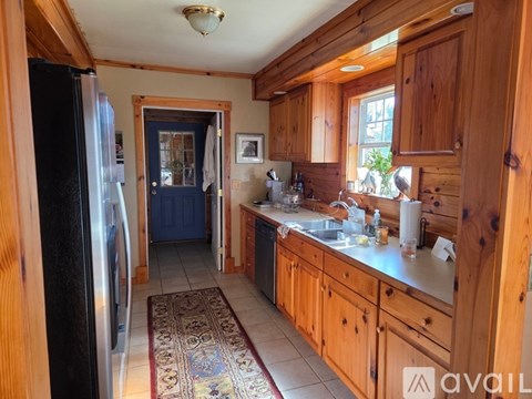 A kitchen with wooden cabinets and a black refrigerator.
