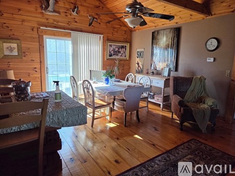A dining room with a table set for six and a ceiling fan.