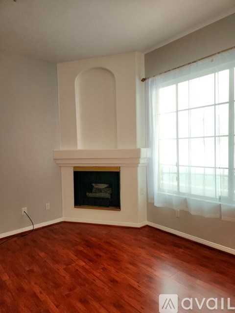 A room with a fireplace and wooden floors.