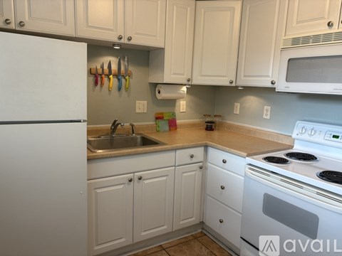 A kitchen with white cabinets and appliances.