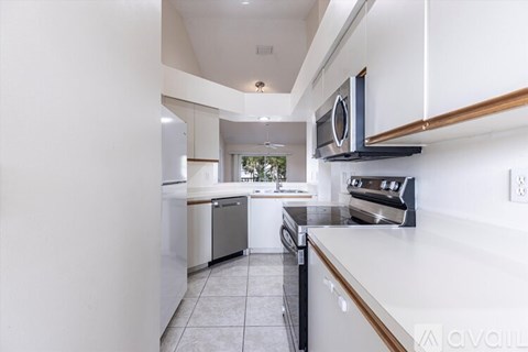 A modern kitchen with white cabinets and stainless steel appliances.