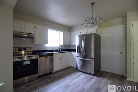 A kitchen with stainless steel appliances and white cabinets.