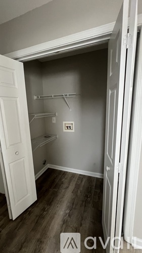 A small, empty closet with a white door and a white shelf.